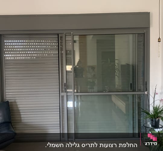 תריסים אפורים סגורים ליד חלון זכוכית